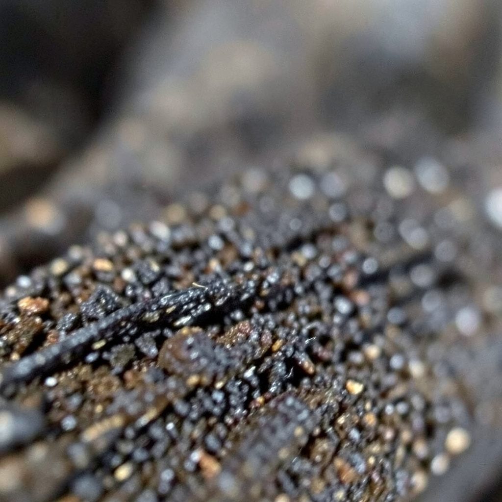 extreme close-up of dark stone texture with fine cracks, muted and serious mood